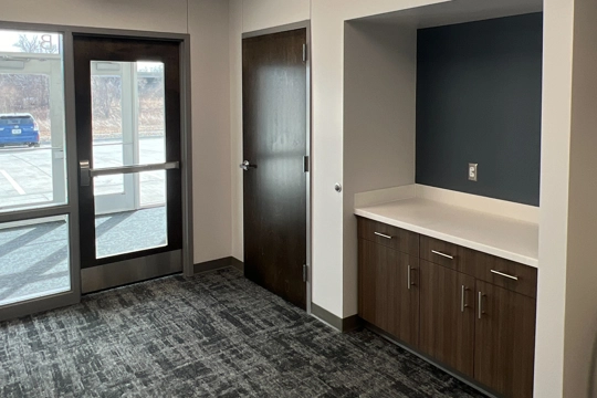 interior of lobby with exterior door in background and built-in cabinetry along right wall in foreground